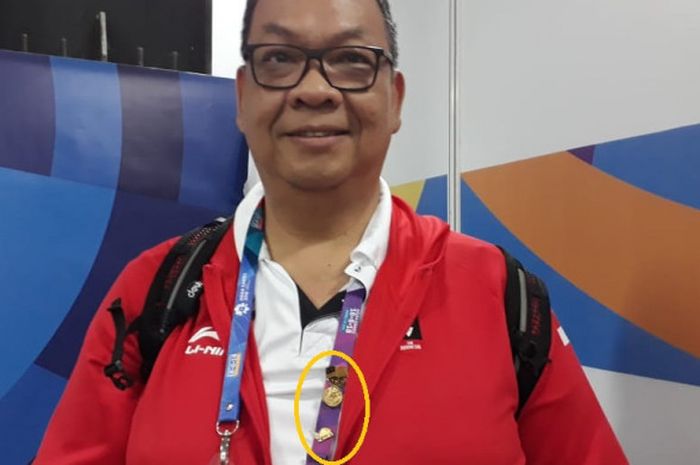 Manajer tim nasional boling memakai pin kenang-kenangan dari beberapa negara saat Asian Games 2018.