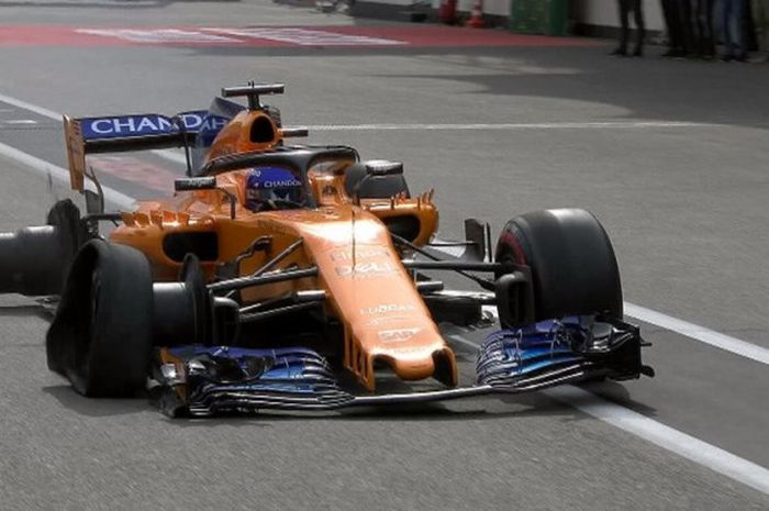 Pebalap McLaren, Fernando Alonso, kermbali masuk pit untuk mengganti ban yang rusak.