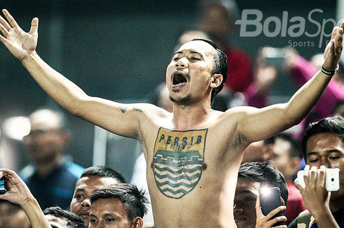 Pendukung Persib Bandung yang dikenal dengan Bobotoh beraksi saat memberi dukungan kepada timnya pada pekan kesepuluh Liga 1 2018 melawan PSM Makassar di Stadion GBLA, Kota Bandung, Rabu (23/05/18). 