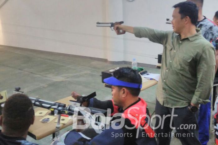  Menteri Pemuda dan Olahraga, Imam Nahrawi (kemeja hijau), saat menjajal kebolehannya dalam menembak pada saat mengunjungi pelatnas NPC menembak di Solo, Selasa (13/3/2018). 