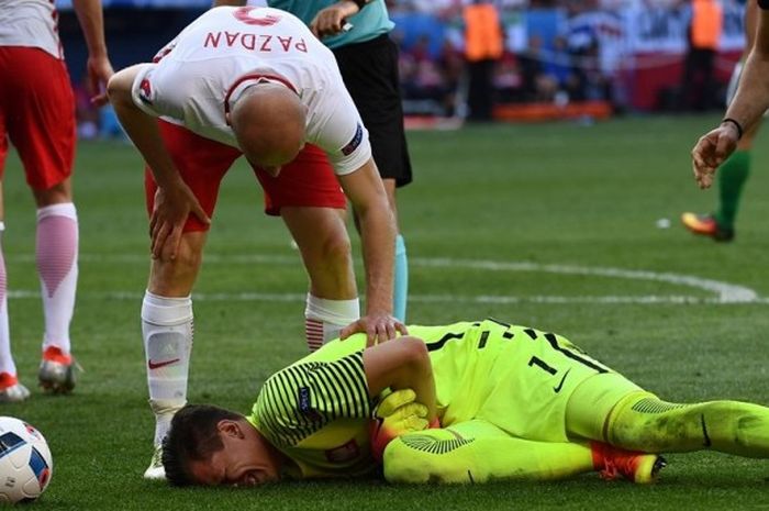 Penjaga gawang Polandia, Wojciech Szczesny, mengalami cedera saat melawan Irlandia Utara pada partai Piala Eropa Grup C di Stade de Nice, 12 Juni 2016.