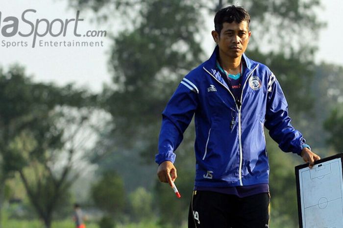 Pelatih Arema FC, Joko Susilo, menenteng papan strategi saat memimpin latihan tim di lapangan Dirgantara Malang, Jawa Timur (07/08/2017).