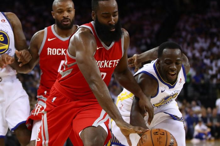 Pebasket Houston Rockets, James Harden (jersey merah), berebut bola dengan pemain Golden State Warriors Draymond Green, pada laga musim reguler NBA 2017-2018 di Oracle Arena, Oakland, California, Amerika Serikat, Selasa (17/10/2017) malam waktu setempat.