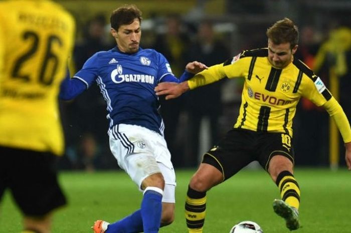 Pemain Borussia Dortmund, Mario Goetze (kanan), berebut bola dengan pilar Schalke 04, Matija Nastasic, saat kedua klub bertemu di Stadion Signal Iduna Park, Sabtu (29/10/2016).