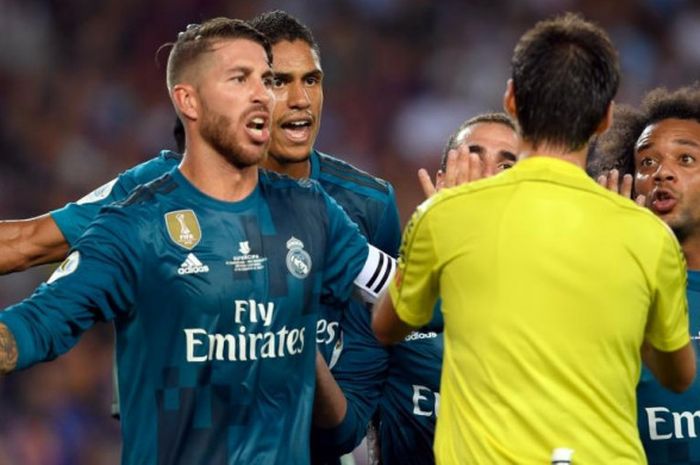 Kapten Real Madrid, Sergio Ramos (kiri), memprotes wasit Ricardo de Burgos dalam partai Piala Super Spanyol kontra Barcelona di Camp Nou, 13 Agustus 2017.