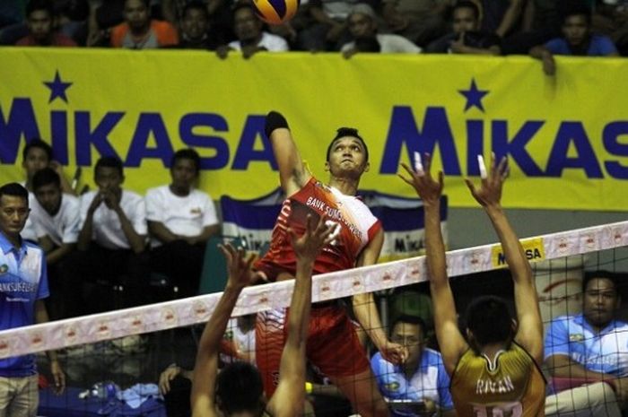 Pemain Bank Sumsel, Sigit Ardian, melepaskan smes yang coba dihadang pemain Surabaya Bhayangkara Samator, Rivan Nurmulki dan Yuda Mardiasyah Putra pada hari ketiga final four Proliga Seri I Solo yang berlangsung di GOR Sritex Arena, Minggu (9/4/2017).