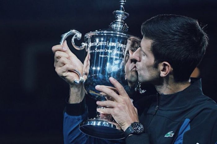 Petenis Serbia Novak Djokovic mencium trofi US Open 2018 usai menang atas Argentina Juan Martin del Potrodi Arthur Ashe Stadium, New York, Amerika Serikat.