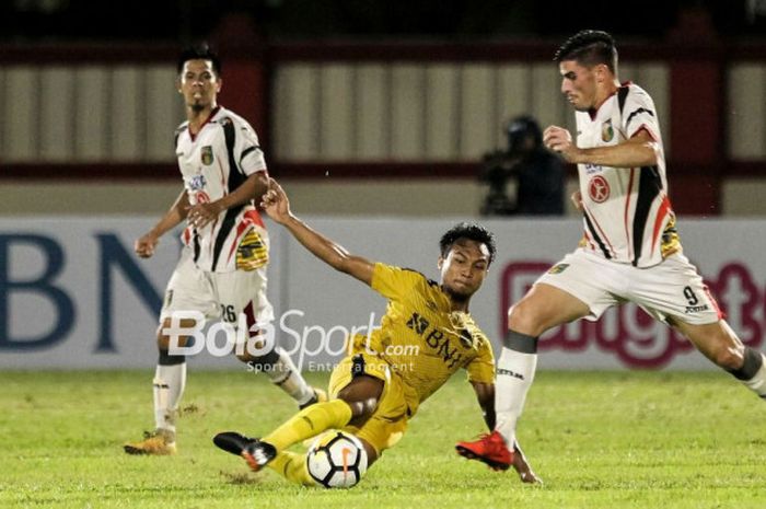 Pemain Bhayangkara FC, Muhammad Hargianto, melepas  tackle ke pemain Mitra Kukar, Fernando Rodriguez