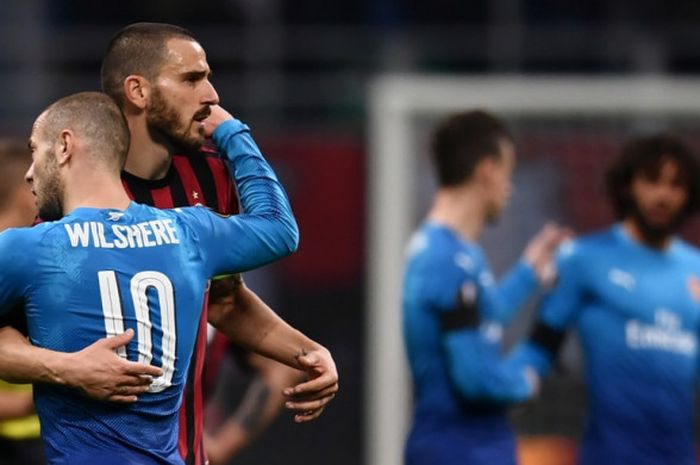  Bek AC Milan, Leonardo Bonucci (kedua dari kiri), memeluk gelandang Arsenal, Jack Wilshere, seusai laga leg pertama babak 16 besar Liga Europa di Stadion San Siro, Milan, Italia pada 8 Maret 2018. 