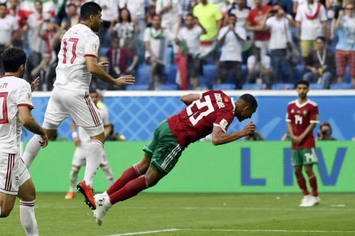 Aksi pemain Maroko, Aziz Bouhaddouz, saat melakukan gol bunuh diri pada pertandingan melawan Iran di Stadion Saint Petersburg, Jumat (15/6/2018) malam WIB.