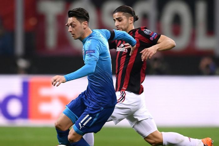 Gelandang Arsenal, Mesut Oezil (kiri), berduel dengan bek AC Milan, Ricardo Rodriguez, dalam laga leg pertama babak 16 besar Liga Europa di Stadion San Siro, Milan, Italia, pada 8 Maret 2018.