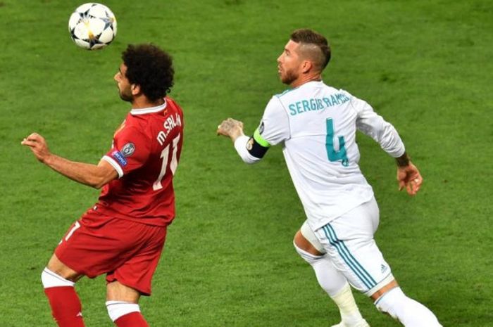   Striker Liverpool, Mohamed Salah (kiri), dikejar oleh bek Real Madrid, Sergio Ramos, dalam laga final Liga Champions di Stadion NSC Olimpiyskiy, Kiev, Ukraina pada 26 Mei 2018.  