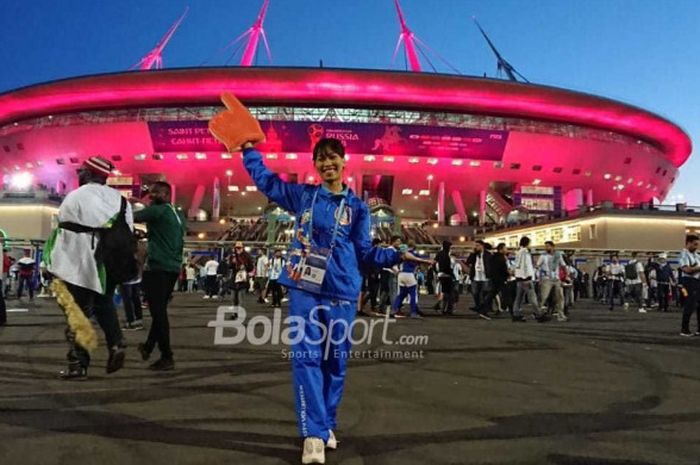 Volunteer Piala Dunia 2018 asal Indonesia, Dinda Maurissa Hartlan, berpose dengan seragamnya di depan Stadion Saint Petersburg seusai laga Nigeria kontra Argentina pada Selasa (26/6/2018).