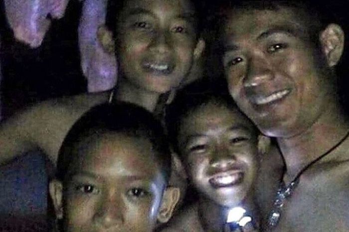 Ini foto pertama para pemain bola Moo Pa dari dalam goa. Lewat Facebook Live, mereka mencoba tersenyum dan menyapa keluarganya.