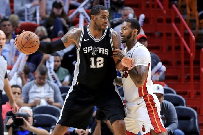 Power forward San Antonio Spurs, LaMarcus Aldrigde (jersey hitam #12), dijaga oleh pemain Miami Heat, James Johnson, pada laga musim reguler NBA 2017-2018 di American Airlines Arena, Miami, Florida, Amerika Serikat, Rabu (25/10/2017).