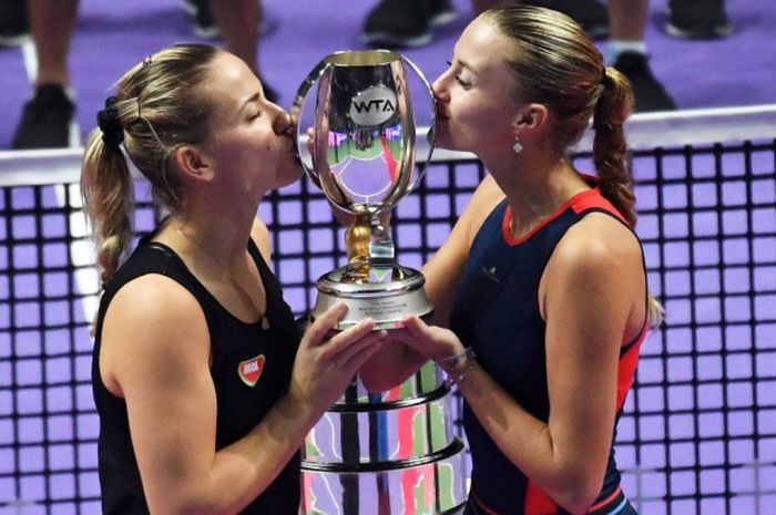 Pasangan ganda putri Hungaria/Prancis, Timea Babos/Kristina Mladenovic, mencium trofi juara yang mereka raih pada WTA Finals 2018 di Singapura. Babos/Mladenovic juara setelah mengalahkan wakil Republik Ceska, Barbora Krejcikova/Katerina Siniakova, pada laga final, Minggu (28/10/2018).