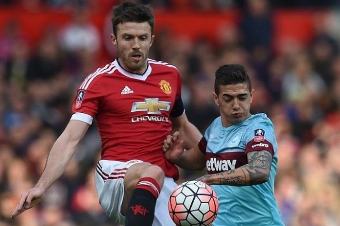 Pemain Manchester United, Michael Carrick (kiri), berduel dengan pemain West Ham United, Manuel Lanzini, pada laga perempat final Piala FA di Stadion Old Trafford, Minggu (13/3/2016). 