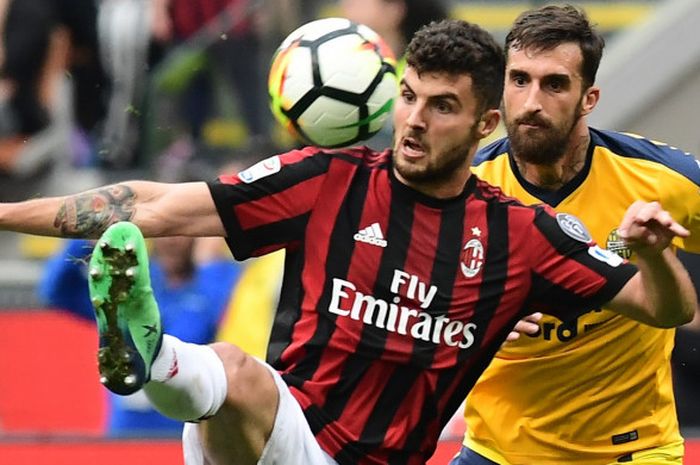 Striker AC Milan, Patrick Cutrone (depan) dibayang-bayangi pemain Hellas Verona, Antonio Caracciolo, dalam pertemuan kedua tim di lanjutan Liga Italia, Sabtu (5/5/2018).