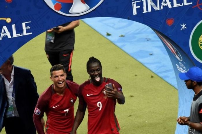   Kapten timnas Portugal, Cristiano Ronaldo, berswafoto dengan Eder sesaat sebelum menaiki tangga Stade de France untuk prosesi penerimaan medali seusai laga Portugal vs Prancis, Minggu (10/7/2016).  