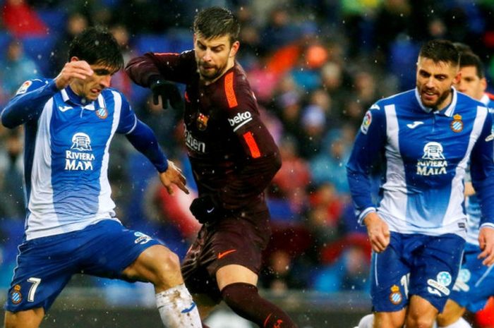 Bek FC Barcelona, Gerard Pique (tengah), berduel dengan striker Espanyol, Gerard Moreno (kiri), dalam laga Liga Spanyol di Stadion RCDE, Cornella de Llobregat, pada 4 Februari 2018.