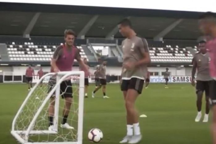 Bek Juventus Daniele Rugani berusaha menggagalkan aksi Cristiano Ronaldo saat sesi latihan.