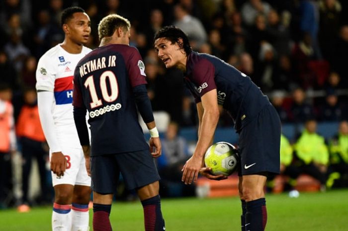 Pemain Paris Saint-Germain, Neymar, berbicara dengan Edinson Cavani yang bersiap mengeksekusi penalti dalam laga Liga Prancis kontra Olympique Lyon di Stadion Parc des Princes, Paris, pada 17 September 2017.