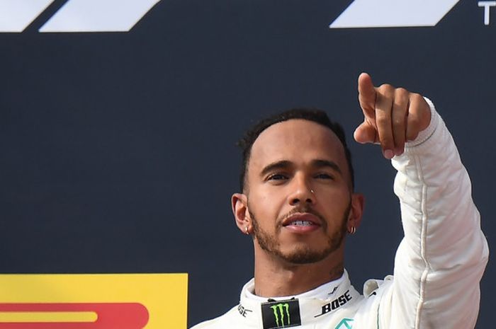   Pebalap Mercedes, Lewis Hamilton, melakukan selebrasi di atas podium setelah memenangi balapan Formula 1 GP Prancis 2018 di Sirkuit Paul Ricard, Le Castellet, Minggu (24/6/2018).  