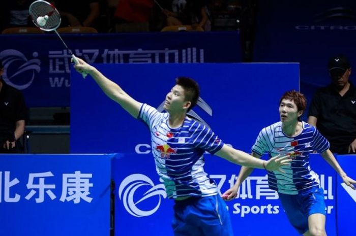 Pasangan ganda putra China, Li Junhui (kanan) dan Liu Yuchen, mengembalikan kok pukulan dari lawan m