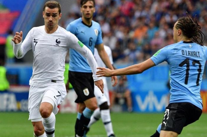 Penyerang Prancis, Antoine Griezmann (kiri) menerobos pertahanan timnas Uruguay dalam partai babak 8 besar Piala Dunia 2018 di Nizhny Novgorod, 6 Juli 2018.