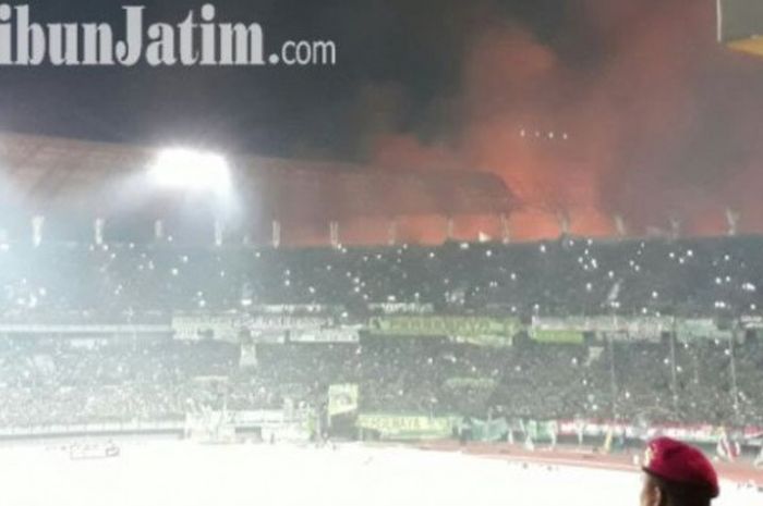 Cahaya yang tampak seperti api terlihat di bagian luar Gelora Bung Tomo saat laga Lanjutan Liga 2 antara tuan rumah Persebaya kontra Persigo Semeru FC, Sabtu (30/9/2017). Kepulan asap juga dilaporkan masuk hingga ke tengah lapangan sehingga pertandingan terpaksa dihentikan.