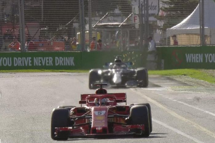 Pebalap Ferrari, Sebastian Vettel, berada di depan pesaingnya Lewis Hamilton (Mercedes) pada balapan F1 GP Australia di Sirkuit Melbourne, Australia, Minggu (25/3/2018).