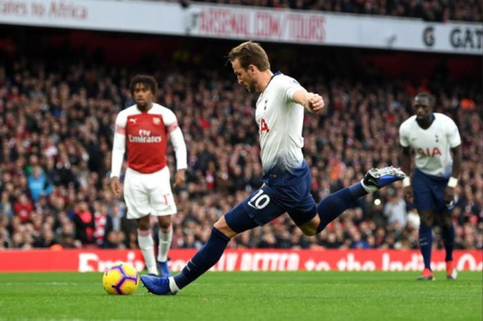 Penyerang Tottenham Hotspur, Harry Kane, mengeksekusi penalti pada laga kontra Arsenal di Stadion Emirates, Minggu (2/12/2018).