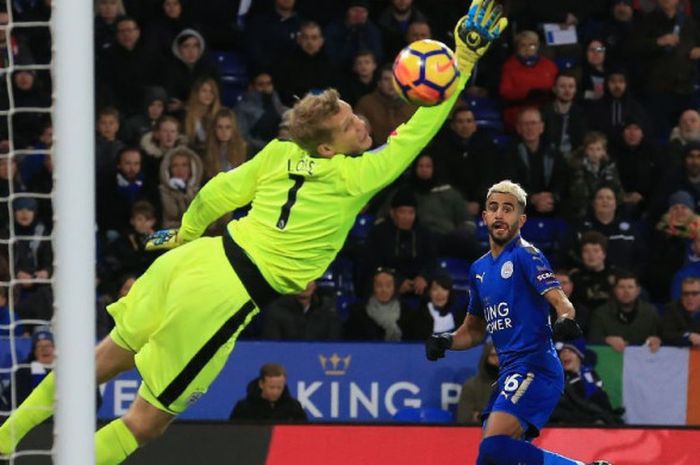 Gelandang Leicester City, Riyad Mahrez, melepas tembakan yang menjebol gawang kiper Huddersfield Town, Jonas Lossl, pada laga Liga Inggris di King Power Stadium, 1 Januari 2018.