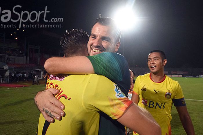 Pelatih Bhayangkara FC, Simon McMenemy, memeluk striker Ilija Spasojevic saat merayakan kemenangan atas Madura United dalam laga pekan ke-33 di Stadion Gelora Bangkalan, Jawa Timur, Rabu (08/11/2017).