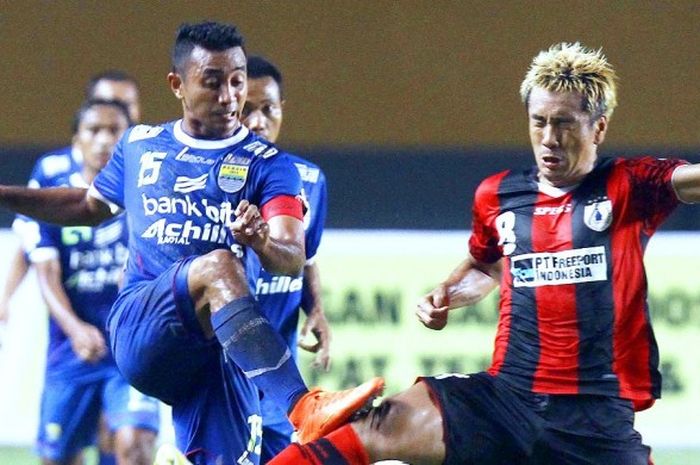 Pemain Persib Bandung (biru) Firman Utina mencoba melewati hadangan pemain Persipura Jayapura Lim Joon-sik (merah) di laga final Liga Super Indonesia 2014 di Stadion Jakabaring, Sumsel, Jumat 7 November 2014.