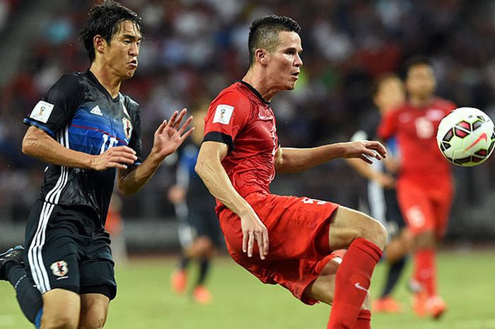 Bek timnas Singapura, Baihakki Hkaizan (kanan), berupaya mengontrol bola dibayangi pemain timnas Jepang, Mu Kanazaki, dalam laga Kualifikasi Piala Dunia 2018 Grup E di Singapura, pada 12 November 2015.