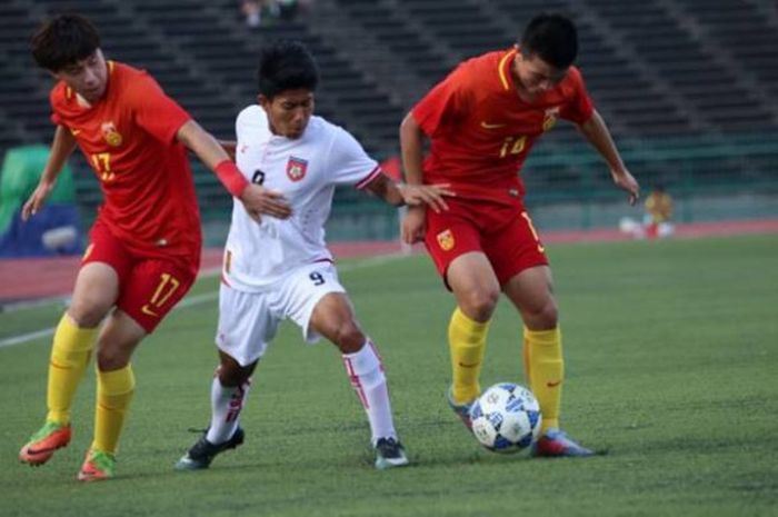 Duo pemain timnas U-19 China, Su Shihao (kiri) dan Tao Qianglong mengapit striker timnas U-19 Myanmar, Hein Htet Aung pada laga pemungkas Grup G Kualifikasi Piala Asia U-19 musim 2017 di National Olympic Stadium, Phnom Pehn, Kamboja, 28 Oktober 2017. 