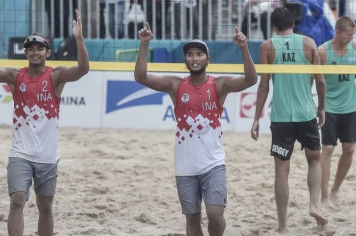 Pebola voli pantai putra Indonesia Gilang Ramadhan (kedua kiri) dan Danangsyah Yudistira Pribadi (kiri) melakukan selebrasi seusai berhasil mengembalikan bola ke arah wakil Kazakstan, Sergey Bogatu (ketiga kiri) dan Dmitriy Yakovlev (kanan) pada pertandingan babak 16 besar voli pantai pria Asian Games 2018 di arena Jakabaring Sport City, Palembang, Sumsel, Jumat (24/8/2018).