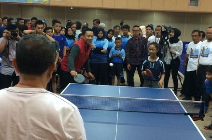 Menpora Imam Nahrawi (jaket merah) berpasangan dengan petenis meja cilik Bunga dari Sekolah Tenis Meja Pacebo bermain pada pembukaan Kejuaraan Nasional Tenis Meja Pelajar 2018 dalam rangka Dies Natalis ke-34 Universitas Terbuka di Pondok Cabe, Tangerang Selatan, 20 Juli 2018.