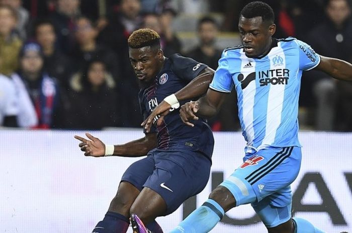 Bek Paris Saint-Germain, Serge Aurier (kiri) berduel dengan pemain Olympique Marseille, Henri Bedimo, dalam pertandingan Ligue 1 2016-2017 di Parc des Princes, Paris, Prancis, pada 23 Oktober 2016. 