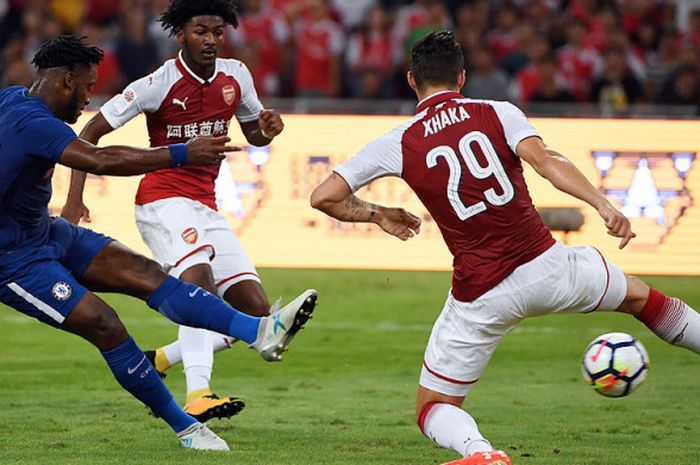 Pemain Chelsea, Michy Batshuayi (kiri), menendang bola melewati pemain Arsenal, Granit Xhaka, dalam laga uji coba pramusim di Stadion Nasional Beijing pada 22 Juli 2017.