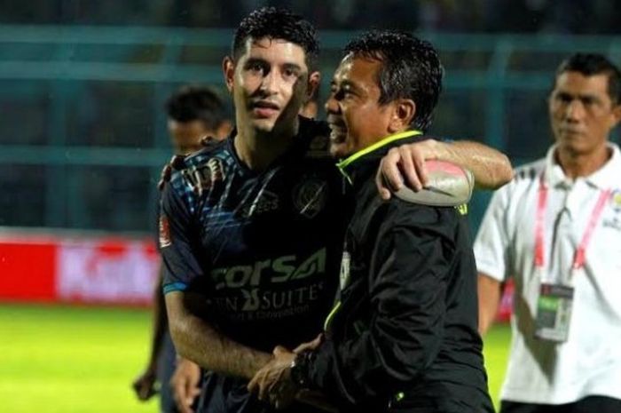 Pelatih Persipura, Jafri Sastra dirangkul gelandang Arema, Esteban Vizcarra selepas laga kedua klub di Stadion Kanjuruhan, Kabupaten Malang, Minggu (26/6/2016) malam. 