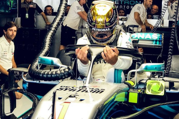 Lewis Hamilton saat bersiap di dalam garasi tim Mercedes jelang mengikuti sesi latihan bebas F1 GP A