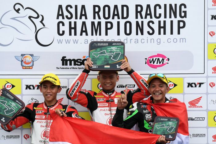 Pebalap AHRT Indonesia, Rheza Danica (tengah), berpose di podium.