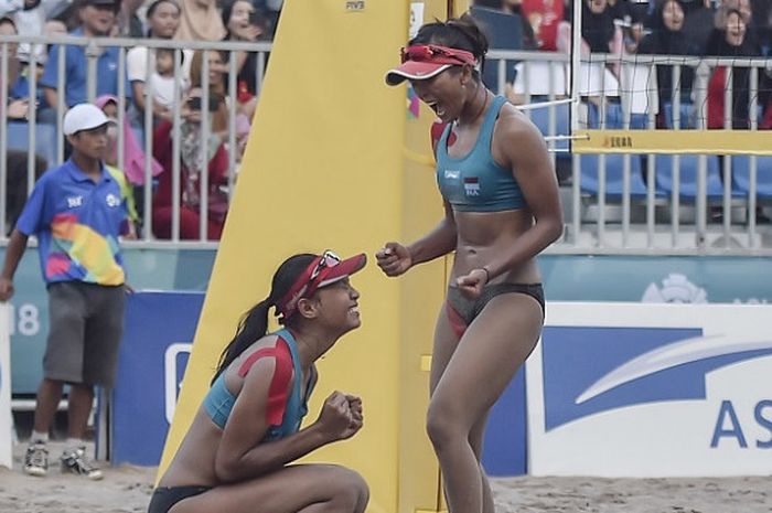 Pebola voli pantai putri Indonesia Dhita Juliana (kiri) dan Putu Dini Jasita Utami (kanan) seusai berhasil mengembalikan bola ke arah Pevoli Chinese Taipei pada pertandingan babak 16 besar voli pantai wanita Asian Games 2018 di arena Jakabaring Sport City, Palembang, Sumsel, Jumat (24/8/2018).