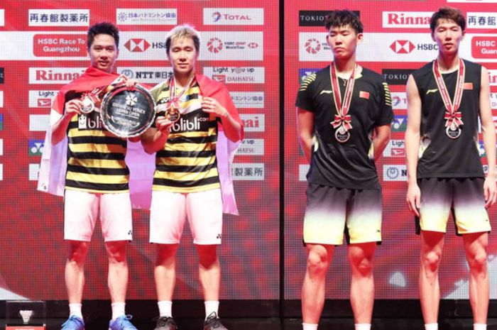 Ganda putra Indonesia Marcus Fernaldi Gideon/Kevin Sanjaya Sukamuljo (kiri) dan Li Junhui/Liu Yuchen (China) berdiri di podium Japan Open 2018 pada Minggu (16/9/2018) di Musashino Forest Sport Plaza, Tokyo.