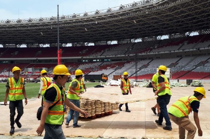 Tim panitia lapangan Asian Para Games 2018 tengah membongkar armor deck di Stadion GBK.