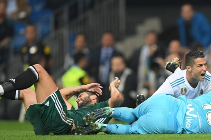 Megabintang Real Madrid, Cristiano Ronaldo, terjatuh dekat kiper Real Betis, Antonio Adan, dalam laga Liga Spanyol di Stadion Santiago Bernabeu, Madrid, pada 20 September 2017.