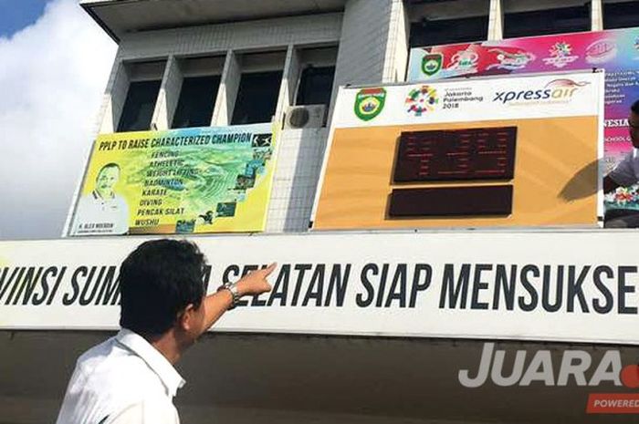 Salah satu pegawai Dinas Pemuda dan Olahraga (Dispora) Sumatera Selatan memasang countdown digital Asian Games 2018 di halaman kantor Dispora Sumsel, Senin (5/6/2017).