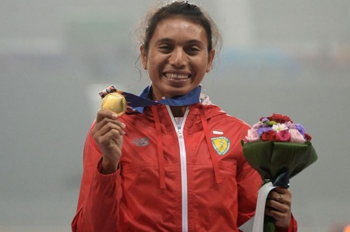  Atlet lompat jauh Indonesia, Maria Londa, berfoto dengan medali emas Asian Games 2014 yang dimenanginya pada nomor lompat jauh di Incheon Asiad Main Stadium, Incheon, 29 September 2014. 